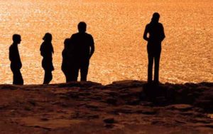 People at the shore at sunset