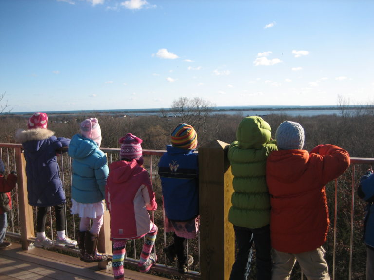 Children on bridge looking out at the ocean