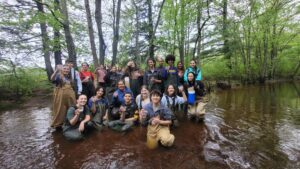 Natalie Tarr - Students and teacher in waders standing in water
