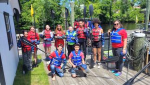 Natalie Tarr - students and teacher wearing life jackets and holding paddles for kayaking