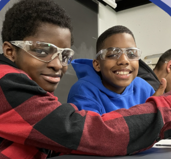 Two children looking at the camera, wearing protective eye gear